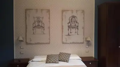 a bedroom with two pictures on the wall and a bed at La Locanda dell'Angelo in Rome