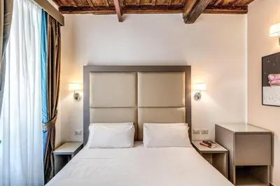 a bedroom with a large bed with two night stands at Reginella Suites in Rome