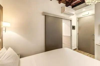 a bedroom with a bed and a sliding door at Reginella Suites in Rome