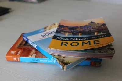 three books stacked on top of each other on a table at Terrazza 29 Holiday Home in Rome
