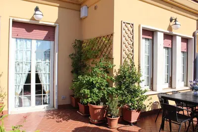a patio with potted plants and a table and windows at Terrazza 29 Holiday Home in Rome