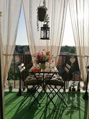 a table with flowers on top of a balcony at Terrazza 29 Holiday Home in Rome