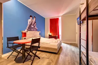 a bedroom with a bed and a table and chairs at MEININGER Roma Termini in Rome