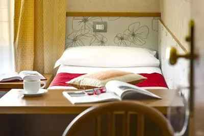 a bedroom with a bed and a desk with a book at Hotel Marcantonio in Rome
