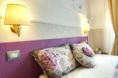 a bedroom with a bed with pillows on it at Hotel Marcantonio in Rome