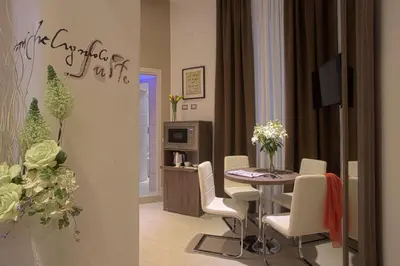 a dining room with a table and white chairs at Hotel Marcantonio in Rome
