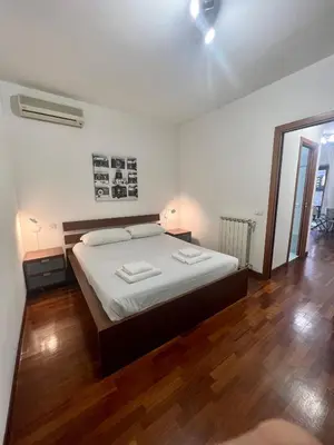 a bedroom with a large bed and a wooden floor at Ponte Milvio - Flat with terrace in Rome