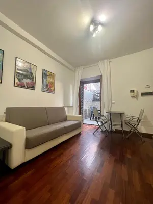 a living room with a couch and a table at Ponte Milvio - Flat with terrace in Rome