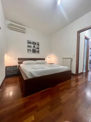 a bedroom with a large bed and a wooden floor at Ponte Milvio - Flat with terrace in Rome