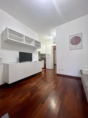 a living room with white furniture and wooden floors at Ponte Milvio - Flat with terrace in Rome