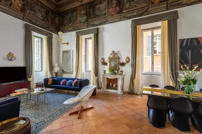 a living room with a blue couch and a table at Experience Collection by ROMAC - Costaguti Experience in Rome