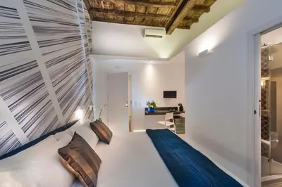 a bedroom with a large white bed with pillows at First Floor - Boutique Hotel in Rome