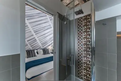 a bedroom with a bed and a glass shower door at First Floor - Boutique Hotel in Rome