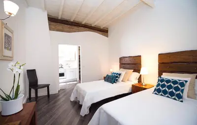 a hotel room with two beds and a chair at DormiRoma - Cedro 21 Apartments in Rome