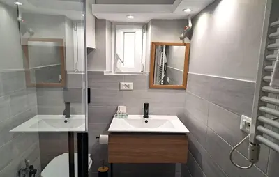a bathroom with two sinks and a mirror at DormiRoma - Cedro 21 Apartments in Rome