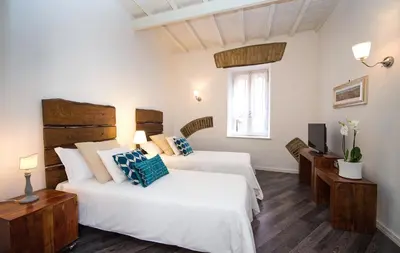 a bedroom with two beds and a television in it at DormiRoma - Cedro 21 Apartments in Rome