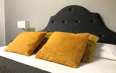 two pillows on a bed with a black headboard at DormiRoma - Cedro 21 Apartments in Rome