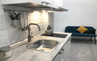 a kitchen with a sink and a blue couch at DormiRoma - Cedro 21 Apartments in Rome