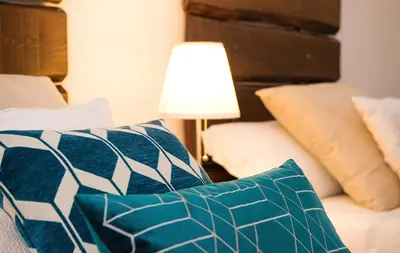 a room with a bed with pillows and a lamp at DormiRoma - Cedro 21 Apartments in Rome