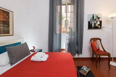 a bedroom with a red bed with a red blanket at Opera House in Rome