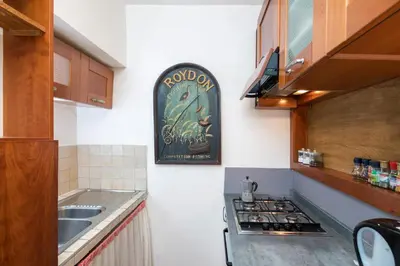 a kitchen with a sink and a clock on the wall at Opera House in Rome