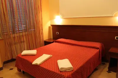 a hotel room with a red bed with two towels on it at Affittacamere Alex in Rome