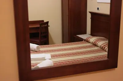 a mirror reflection of a bed in a room at Affittacamere Alex in Rome