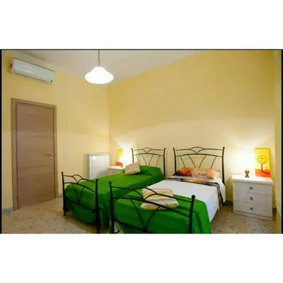 two beds in a bedroom with green sheets at Domus Ines Roma San pietro in Rome