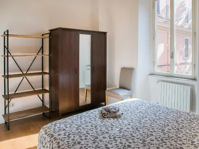 a bedroom with a bed and a wooden cabinet at Domus Claudi Colosseum in Rome