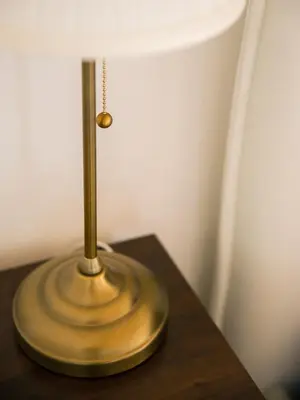 a brass lamp sitting on top of a wooden table at Domus Claudi Colosseum in Rome