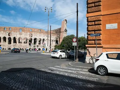 a city street with cars parked in front of a building at Domus Claudi Colosseum in Rome