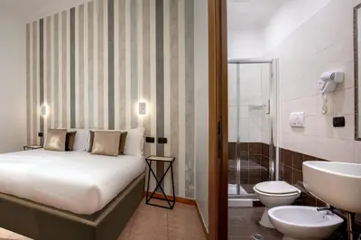 a bathroom with a bed and a sink and a toilet at Hotel Ciao in Rome