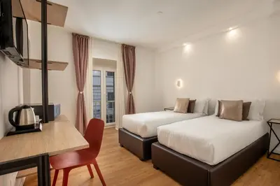 a bedroom with a large white bed and a window at Hotel Ciao in Rome