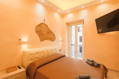a bedroom with a bed and a flat screen tv at Spartacus Inn Apartment in Rome