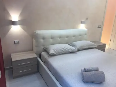 a bedroom with a large white bed with two lamps at Spartacus Inn Apartment in Rome