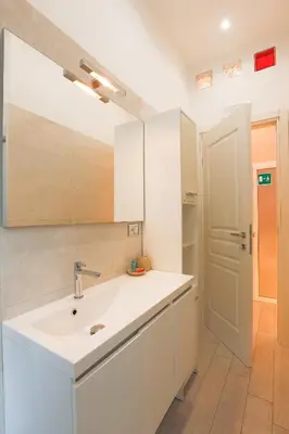 a white bathroom with a sink and a mirror at Spartacus Inn Apartment in Rome