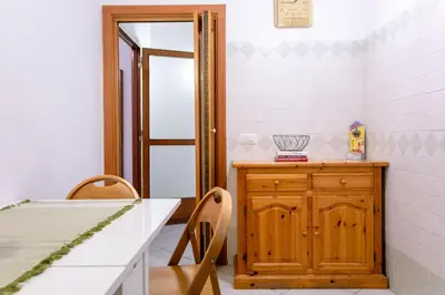 a kitchen with a table and a wooden cabinet at Perfetto per Famiglie Appartamento Accogliente e Spazioso a 15 min dalla Metro in Rome