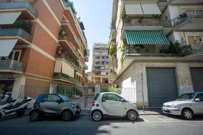 a group of cars parked in a parking lot next to buildings at Perfetto per Famiglie Appartamento Accogliente e Spazioso a 15 min dalla Metro in Rome