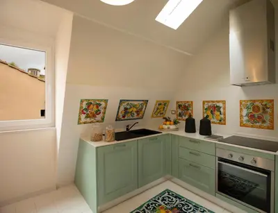 a kitchen with green cabinets and a sink at Elizabeth Unique Hotel | a Member of Design Hotels™ in Rome