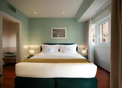 a bedroom with a large bed and two windows at Elizabeth Unique Hotel | a Member of Design Hotels™ in Rome