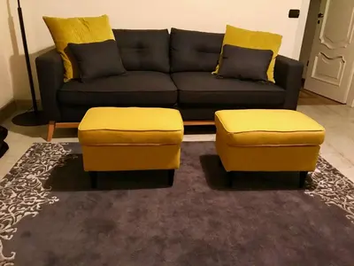 a living room with a couch and two yellow ottools at Sweethome Crispi in Rome