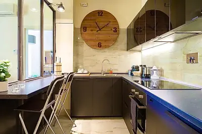 a kitchen with a counter and a clock on the wall at Sweethome Crispi in Rome
