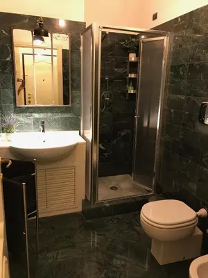 a bathroom with a shower and a toilet and a sink at Sweethome Crispi in Rome