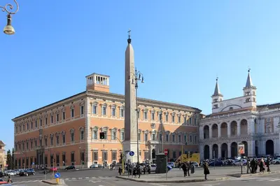 a tall obelisk in the middle of a city street at Appartamento d'epoca Colosseo Art Gallery in Rome