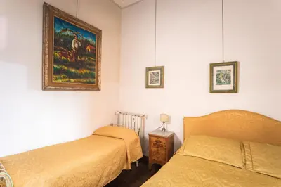 a bedroom with two beds and a painting on the wall at Appartamento d'epoca Colosseo Art Gallery in Rome