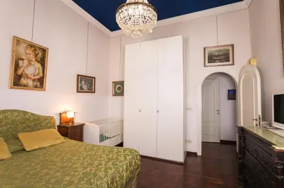 a bedroom with a bed and a chandelier at Appartamento d'epoca Colosseo Art Gallery in Rome