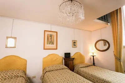 a bedroom with two beds and a chandelier at Appartamento d'epoca Colosseo Art Gallery in Rome