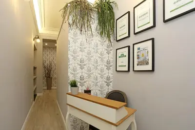 a hallway with a console table and framed pictures on the wall at Capricci Romani in Rome