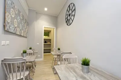 a restaurant with tables and chairs and a clock on the wall at Capricci Romani in Rome