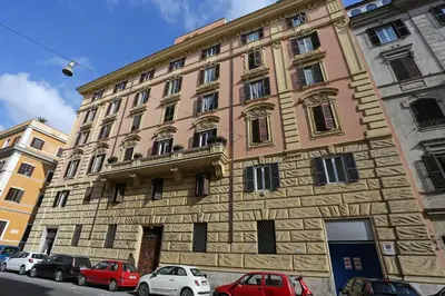 a large building with cars parked in front of it at Capricci Romani in Rome